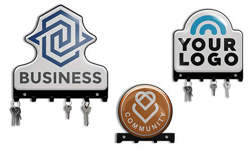 Tres ganchos de llaves con logotipos: BUSINESS con patrón azul, YOUR LOGO con arco, COMMUNITY con corazón, con llaves