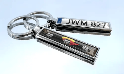 Metal comic keychain with car design and license plate detail
