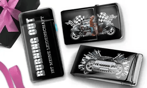 Drei glänzende Zigarettenetuis mit Automotiv. Eines trägt die Aufschrift „Burning Out Ist Meine Leidenschaft“. Die anderen zeigen ein Motorrad und ein Sportauto mit karierten Flaggen.