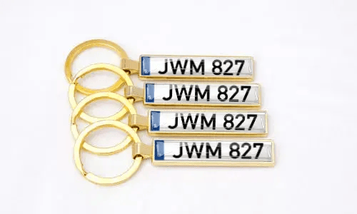 Gouden metalen nummerplaat sleutelhangers benadrukken gepersonaliseerde auto-accessoires