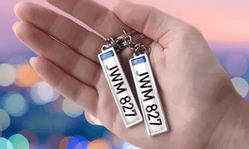 Portachiavi con targa personalizzata e numeri personalizzati, tenuto in mano