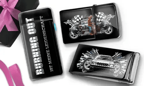 Drei glänzende Zigarettenetuis mit Automotiv. Eines trägt die Aufschrift „Burning Out Ist Meine Leidenschaft“. Die anderen zeigen ein Motorrad und ein Sportauto mit karierten Flaggen.