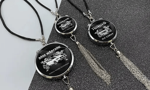 Three black pendants with chains: each with car graphic and German tuning slogan on glittery surface