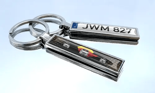Set aus Metall-Comic-Auto-Schlüsselanhängern mit bunten Rennfahrzeug-Designs