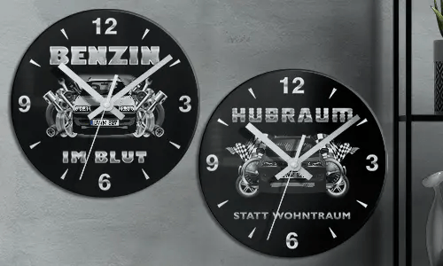 Zwei schwarze Wanduhren mit Autoillustrationen und deutschem Text: BENZIN IM BLUT und HUBRAUM STATT WOHNTRAUM