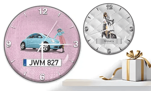 Zwei Wanduhren mit weiblichen Figuren und Fahrzeugen: links mit schwarzem Auto vor lila Wellen, rechts mit rotem und schwarzem Auto, Rennflaggen und blauem Hintergrund