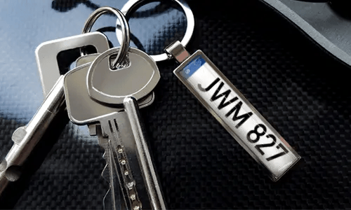 Porte-clés avec pendentif illustrant une voiture et anneau en métal